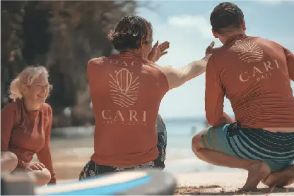 A surf coach from Cari Bali gestures while teaching a student on the beach