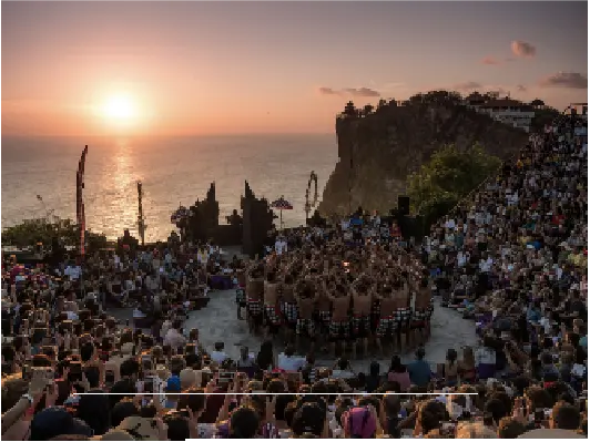 Kecak dance performance at Uluwatu Temple in Bali at sunset with a large crowd watching