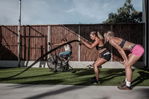 Female Ultimate Riders attendant is training surf strength with instructor at 360 Move Uluwatu, Bali.