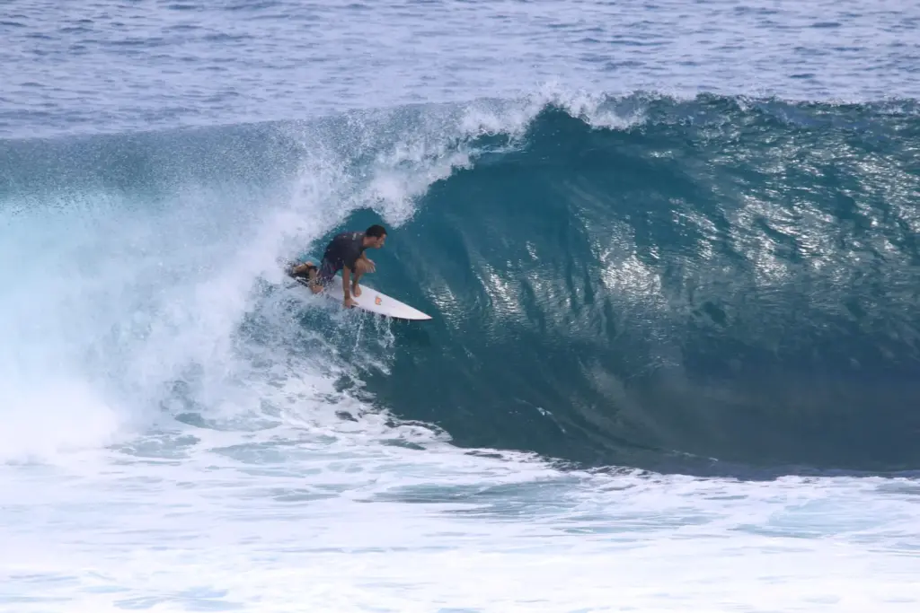 Surfer riding a green wave