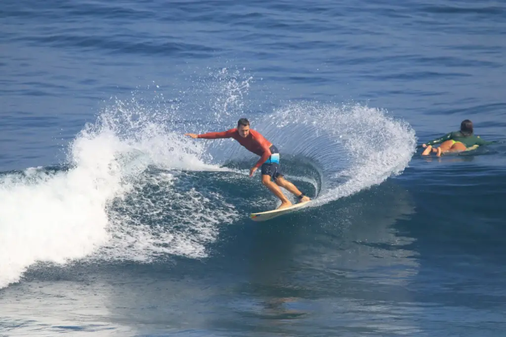 Surfer riding a wave through sea spray